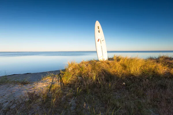 Prancha de surf bateu na areia na costa do mar — Fotografia de Stock