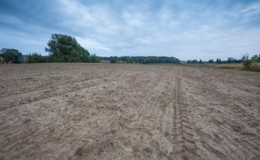 Bulutlu gökyüzü altında güzel sürülmüş alan.