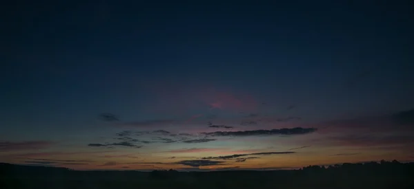 Vackra efter solnedgång himlen över fälten — Stockfoto