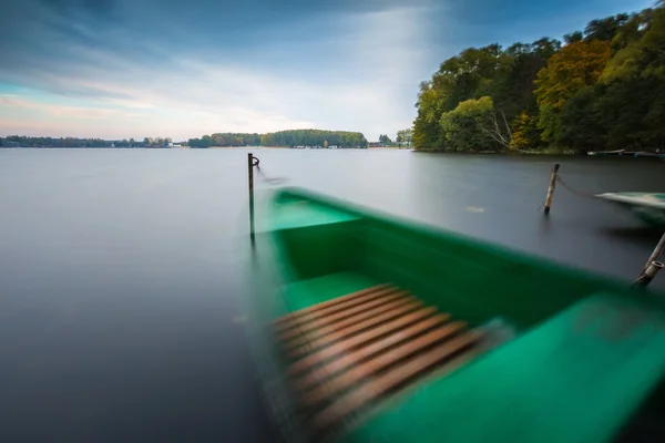 De oever van het meer met afgemeerd boot. Lange blootstelling — Stockfoto