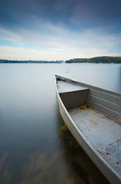 De oever van het meer met afgemeerd boot. Lange blootstelling — Stockfoto