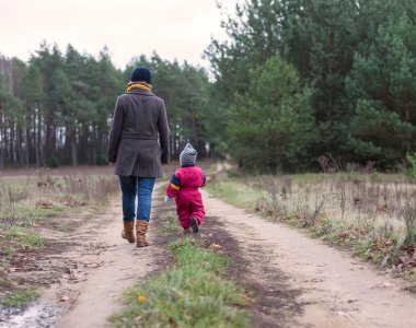 Ormandaki kırsal kumlu karayoluyla yürüyüş çocuk ile anne