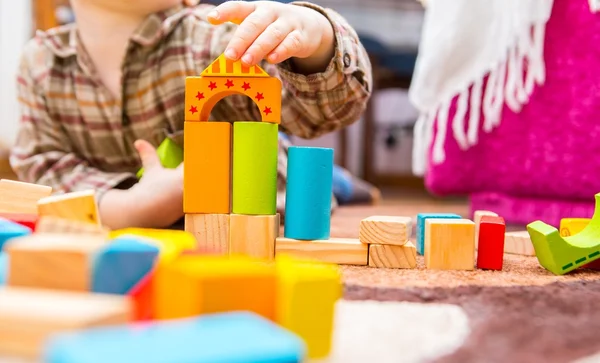 Маленька дитина грає з дерев'яними блоками — стокове фото