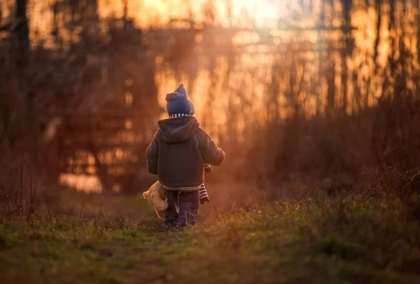 Kleine jongen spelen buiten op de oever van het meer. — Stockfoto