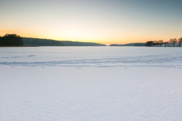 Céu do por do sol sobre lago congelado e nevado . — Fotografia de Stock