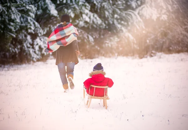 Ragazzo e sua madre giocano nel paesaggio invernale. Modello bambino — Foto Stock