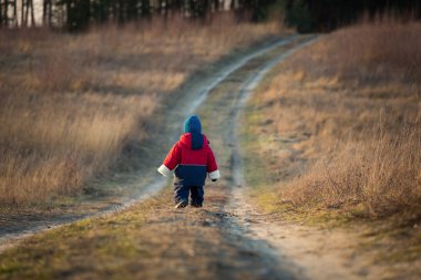 Young happy boy playing outdoor on country road