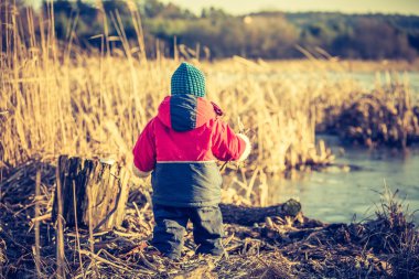Göl kenarında bahar peyzaj açık oynayan genç mutlu çocuk