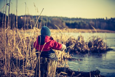 Göl kenarında bahar peyzaj açık oynayan genç mutlu çocuk