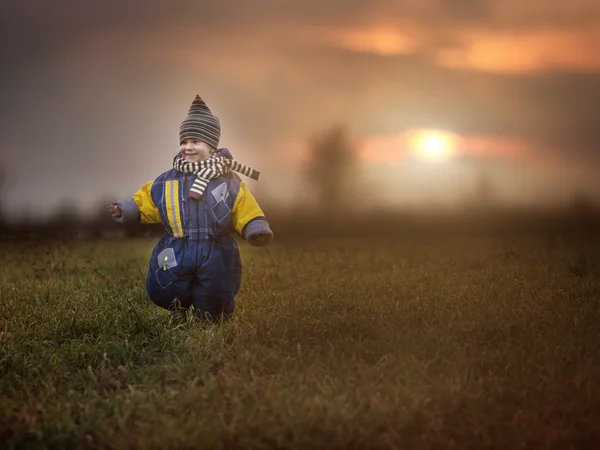Chlapeček hraje venkovní v podzimní nebo jarní krajina. — Stock fotografie
