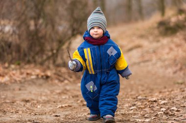 Ormanda erken Bahar oynarken küçük beyaz çocuk