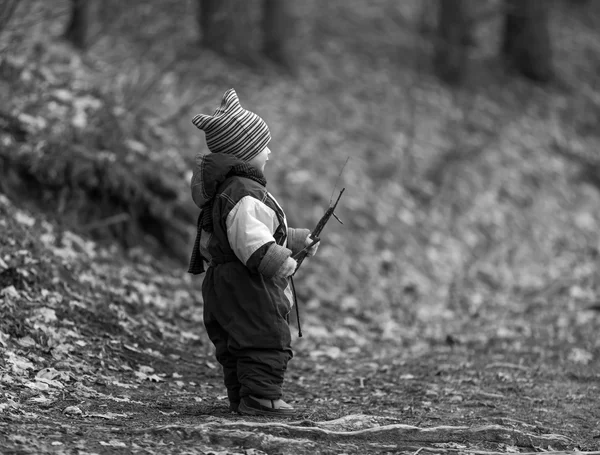 Pequeño chico caucásico jugando en el bosque a principios de primavera — Foto de Stock