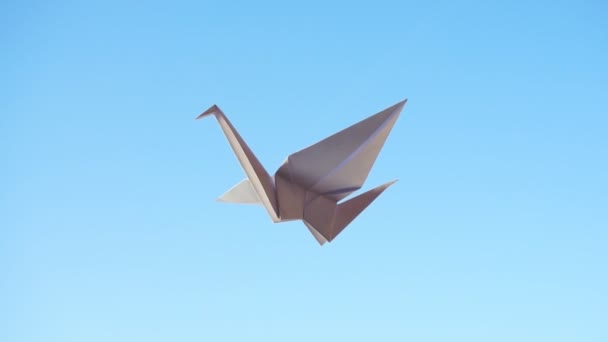 折り紙鳥 青い背景に飛ぶ折り紙の鳥 — ストック動画