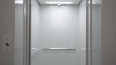 Konut binasında ya da ofiste boş bir asansör. Modern asansör veya metalden yapılmış asansör kapıları sorunsuzca açılıp kapanır 