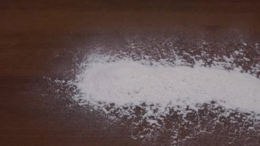 Karanlık bir masanın üzerine un yığını. Dökülmüş un. Un dokusu
