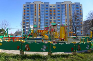 Çocuk parkında renkli slaytlar ve salıncaklar. Bir apartmanın yakınındaki boş çocuk parkı