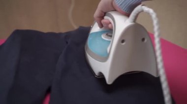  Ütü masasında ütülü giysiler. Erkek eli ütü masasında demir pantolon. 360 derece izleme yayı atışı