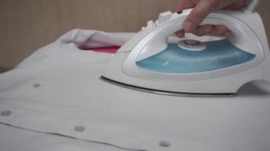   Giysileri ütüleyen adam. Ütü masasında ütülü giysiler. 360 derece izleme yayı atışı