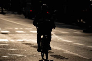 Bisikletçiler kışın Paris 'te bir caddede pedal çeviriyor.