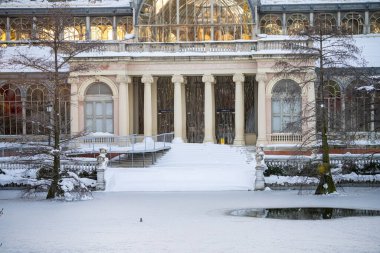 Yoğun bir kar yağışından sonra, gün batımında Retiro Park 'taki Kristal Saray