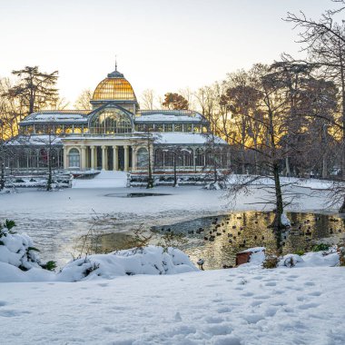 Yoğun bir kar yağışından sonra, gün batımında Retiro Park 'taki Kristal Saray
