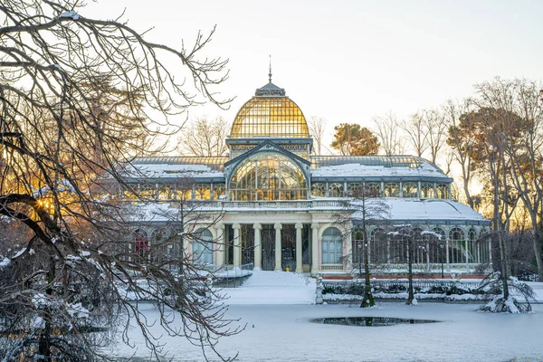 Yoğun bir kar yağışından sonra, gün batımında Retiro Park 'taki Kristal Saray