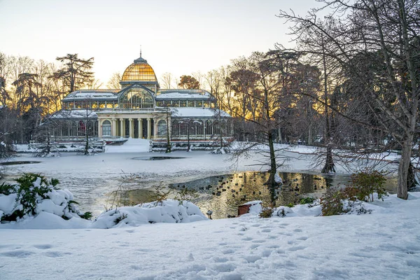 Yoğun bir kar yağışından sonra, gün batımında Retiro Park 'taki Kristal Saray