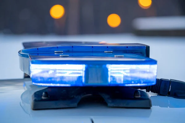 Polis arabasının tepesindeki mavi ışıklar. Arka plan bulanık. Işıklar da bokeh etkisi yapıyor.