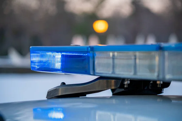 Polis arabasının tepesindeki mavi ışıklar. Arka plan bulanık. Işıklar da bokeh etkisi yapıyor.