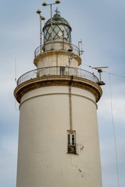 İspanya, Endülüs 'ün güneyindeki Malaga' nın göbeğindeki beyaz deniz feneri, güneşli bir yaz gününde gün batımında