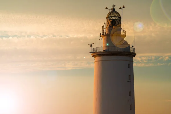 İspanya, Endülüs 'ün güneyindeki Malaga' nın göbeğindeki beyaz deniz feneri, güneşli bir yaz gününde gün batımında