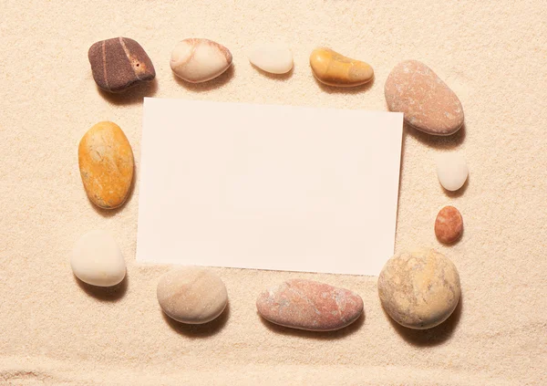 Quadro de pedras marinhas com cartão de visita branco na areia — Fotografia de Stock