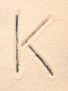 Kum üzerinde yazılı K harfi