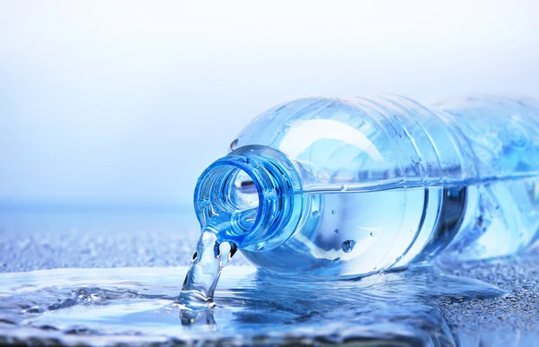 Plastik şişe yansıması ile dökülen su 