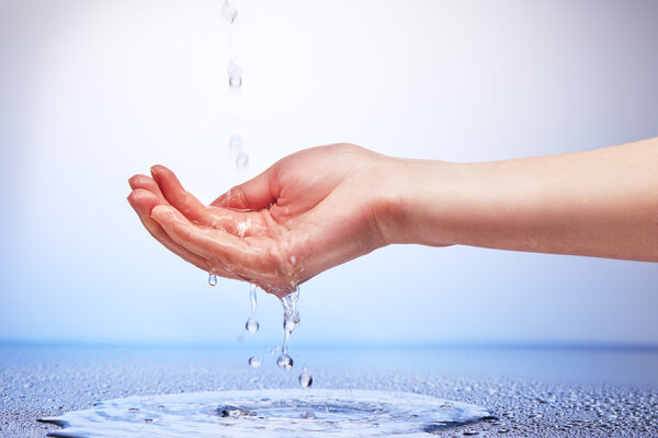 Water falling in women hand 