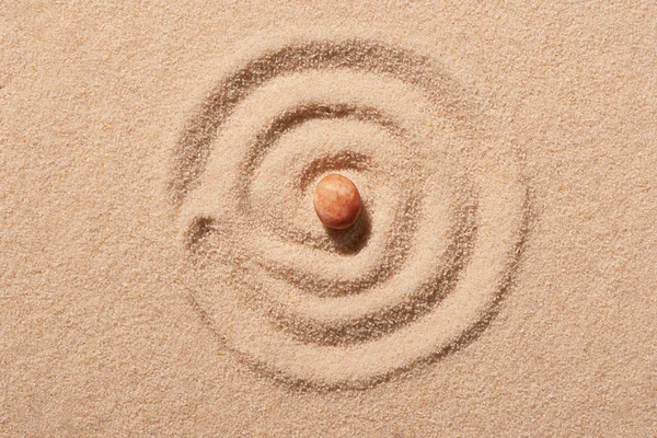 Espiral desenhado em areia de praia com rosa pedra do mar redondo no centro — Fotografia de Stock