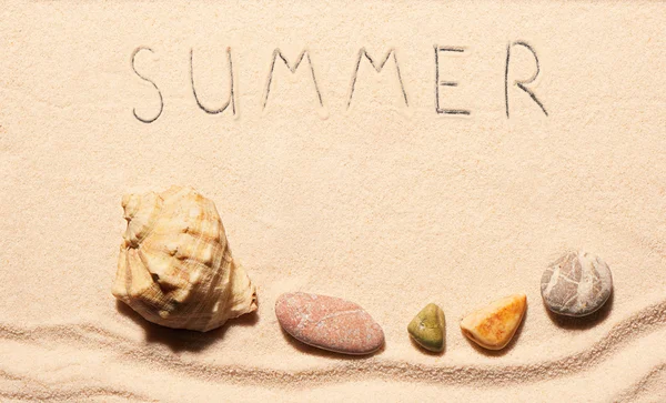 Seashell, sea stones and summer lettering drawn on sand — Stock Photo, Image
