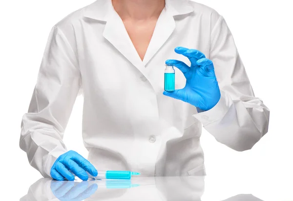 Doctor holding syringe and ampoule with blue drug against white — Stock Photo, Image