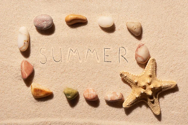 Frame of sea stones and starfish with summer on sand — Stock Photo, Image