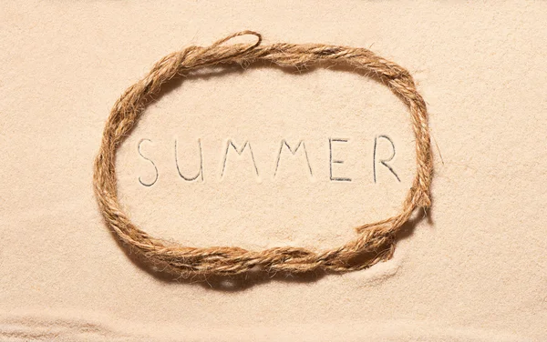 Oval frame of rope with summer lettering drawn on sand — Stock Photo, Image