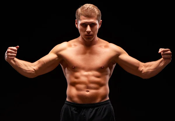 Homem poderoso muscular com tronco nu e braços tensos levantados — Fotografia de Stock