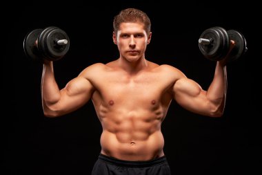 Sportsman with serious face and dumbbells in his hands
