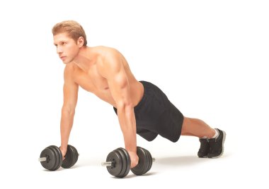 Muscular sportsman doing push-ups with dumbbells on white background