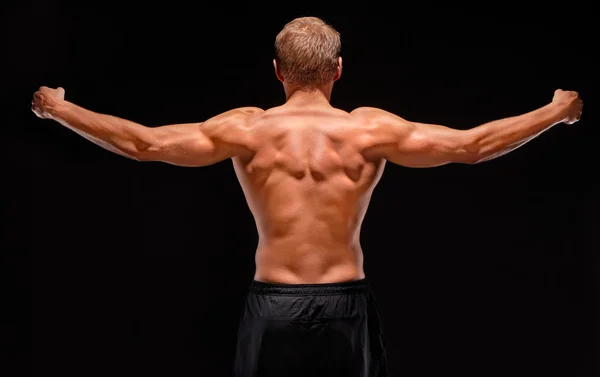 Visão traseira do desportista muscular sexy com os braços esticados — Fotografia de Stock
