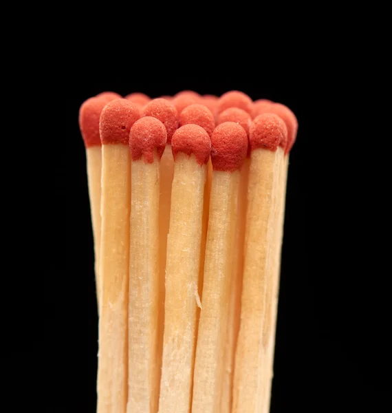 Gruppo di fiammiferi in legno rosso isolati su sfondo nero Foto Stock