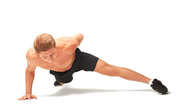 Young muscular handsome shirtless sportsman doing push-ups on one arm