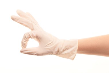 Female doctor's hand in white surgical glove showing OK sign