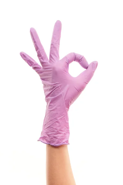 Female doctor's hand in purple surgical glove showing OK sign — Stok fotoğraf