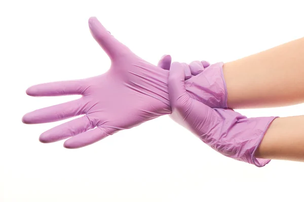 Manos de doctora poniéndose guantes quirúrgicos esterilizados morados — Foto de Stock
