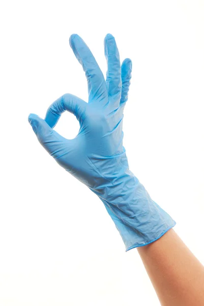 Женская рука врача в синей хирургической перчатке показывает знак ОК — стоковое фото